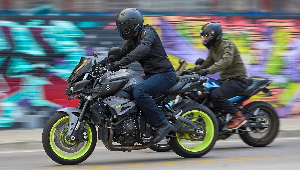 Two naked bike riders tear through a heavily graffiti'd alleyway.
