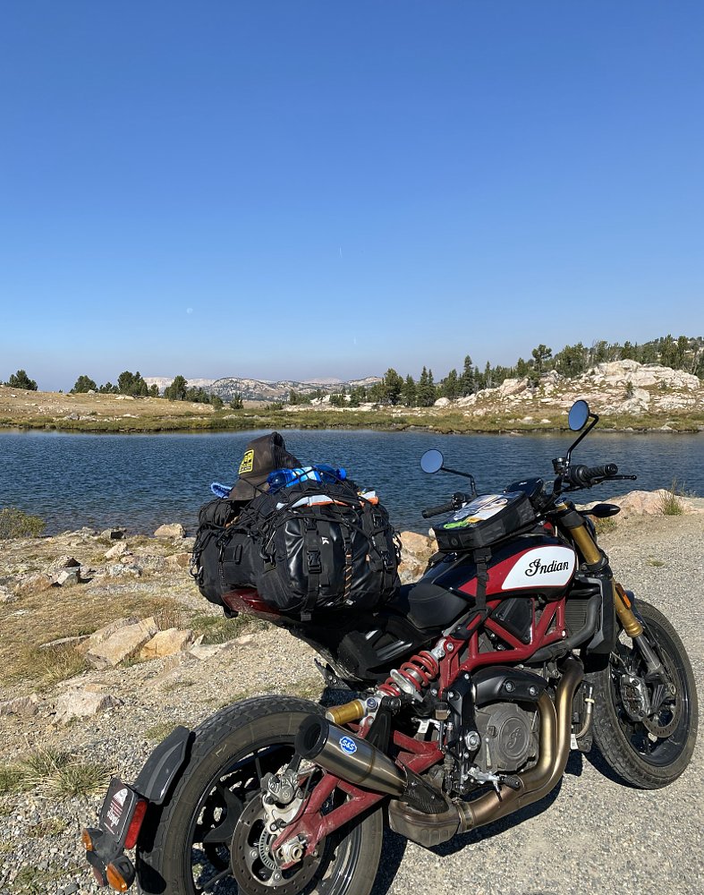 motorcycle parked by a high mountain lake