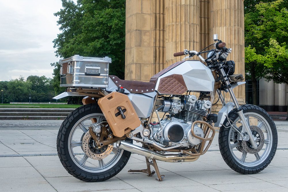 silver desert sled-style motorcycle with a fuel tank shaped with sharp creases