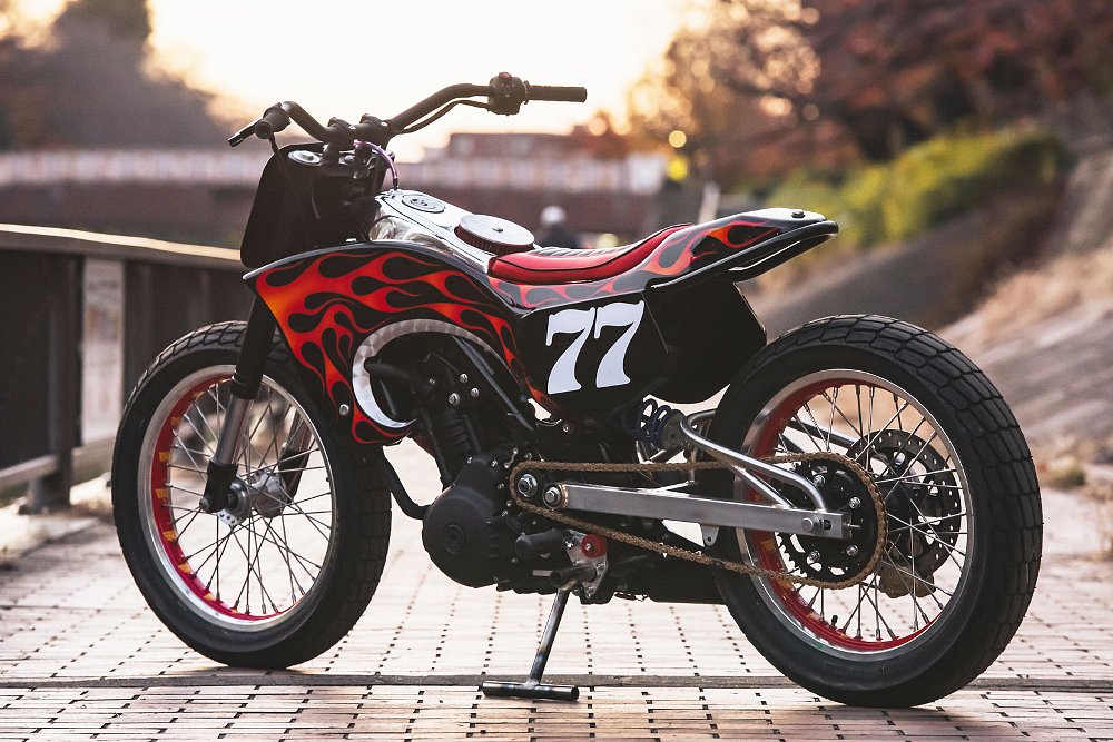 red custom flat-track style motorcycle with number plate