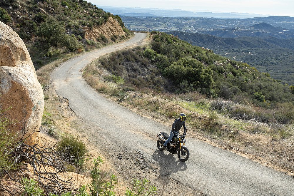 A wide shot of Dustin riding the Scrambler 900 along a mountain road.