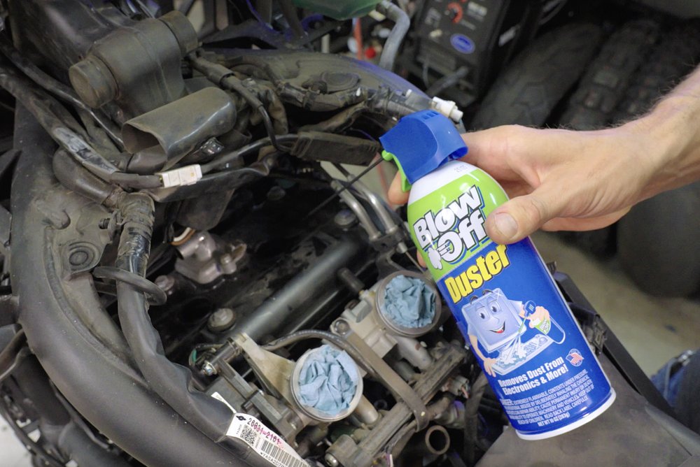 Canned air to remove debris from spark plug hole