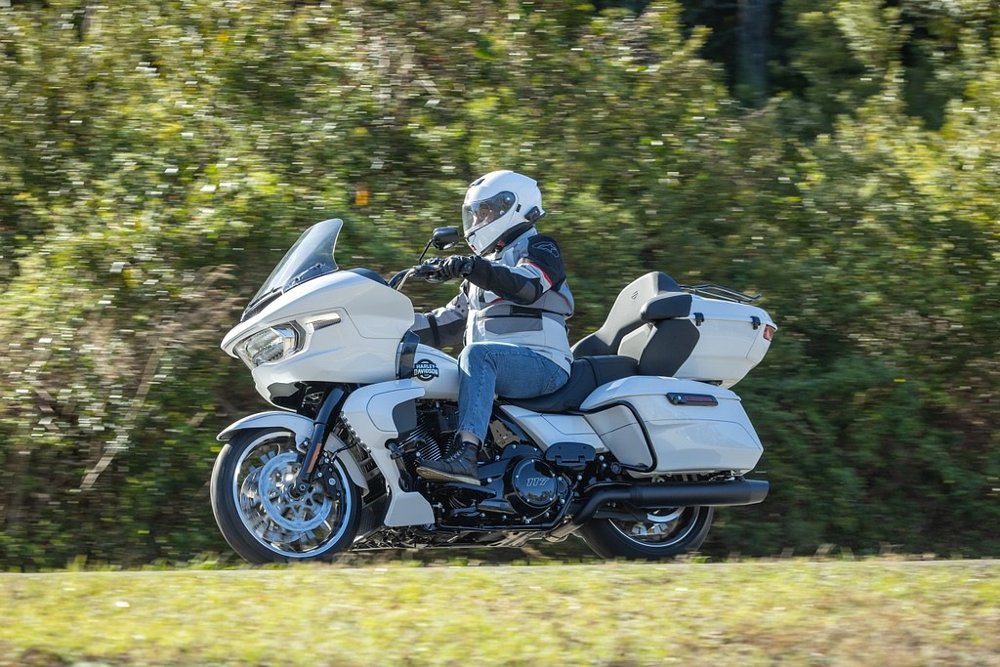 rider on a white Road Glide on a tree-lined road
