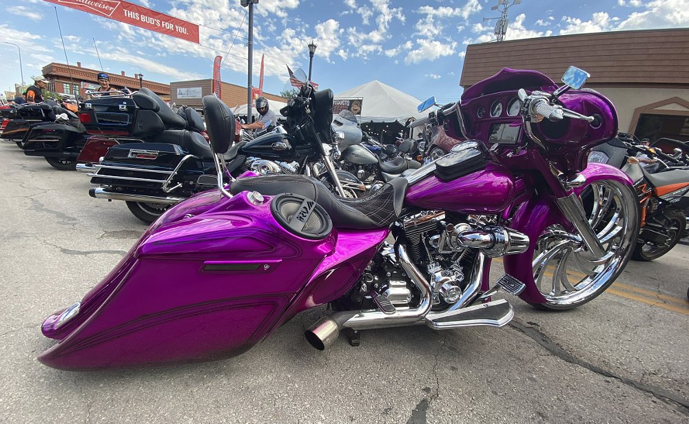 purple big wheel bagger with lowered suspension parked at a motorcycle event