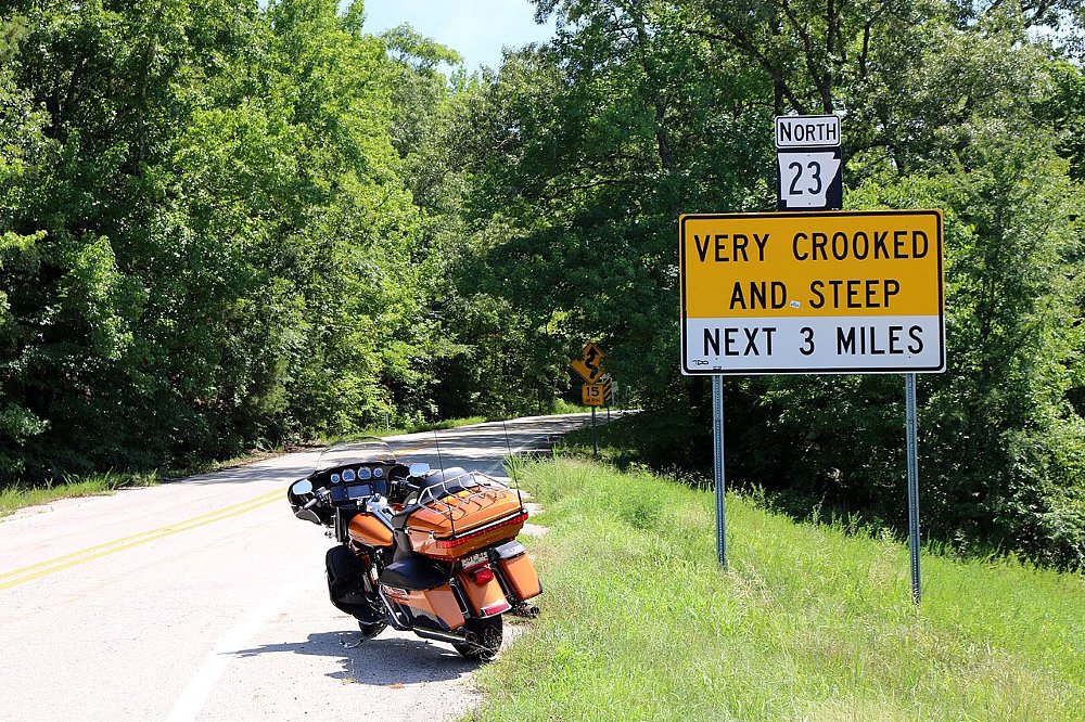 sign warning of crooked and steep road